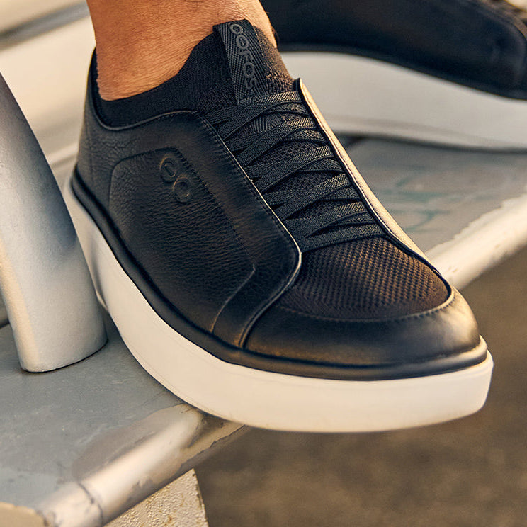 Black sneakers with white soles on a metal surface | lifestyle