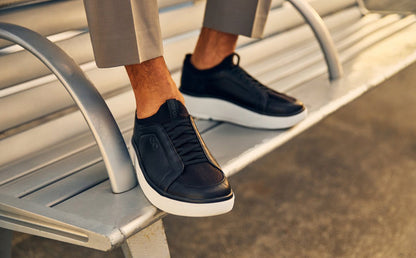 Black sneakers with white soles on a metal surface | lifestyle