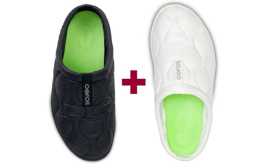 Black and white slip-on shoes with green soles on a white background