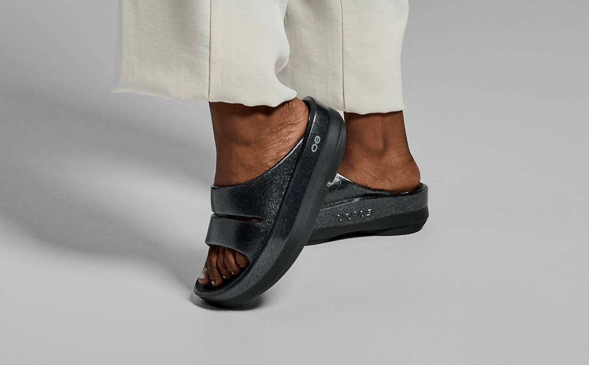 Women's OOmega OOahh Stacked Sandal - Black Sparkle model posing in studio | lifestyle