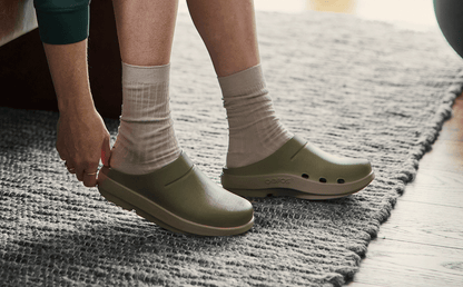 Women's OOcloog Luxe Clog - Foliage model sitting adjusting shoe inside | lifestyle