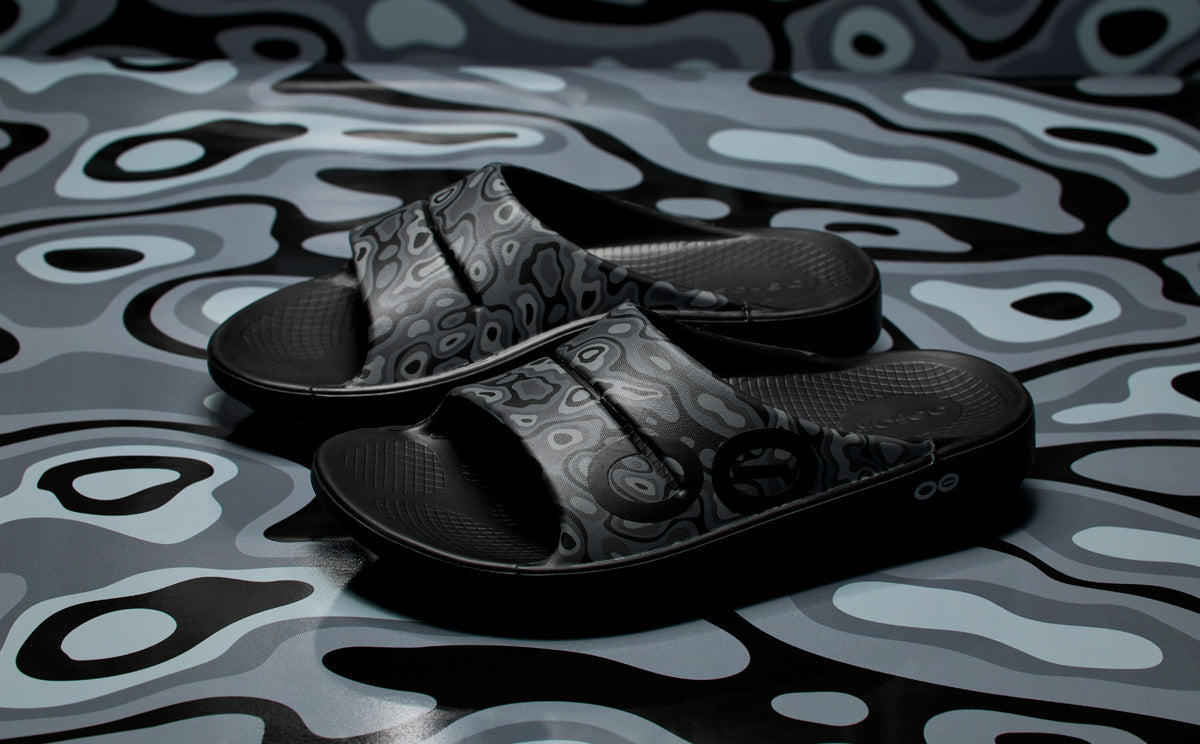 OOahh Sport Slide Sandal - Black Water Camo product against camo background | lifestyle