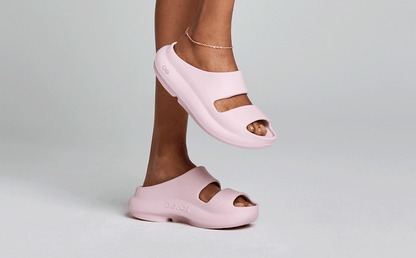 Women's OOyea Slide Sandal - Primrose model standing on one foot in studio | lifestyle