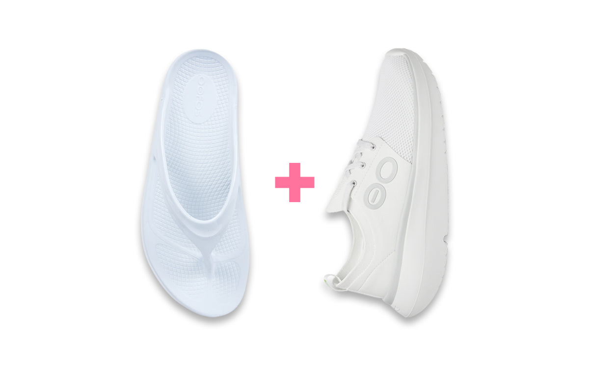White sneakers with a pink plus sign between them on a white background