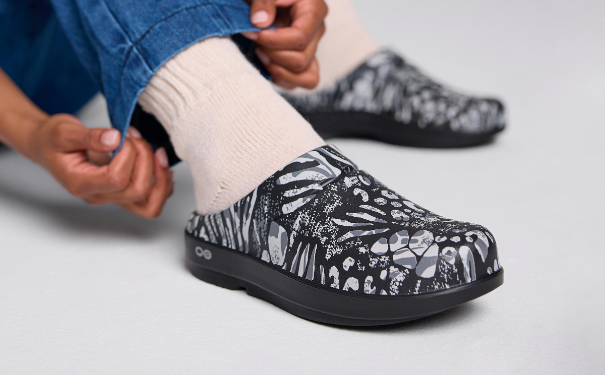 Women's OOcloog Limited Edition Clog - Combo Camo model sitting in studio | lifestyle