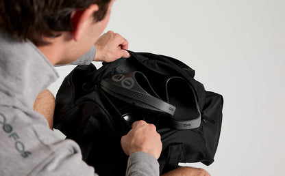 Men's OOahh Sport Slide Sandal - Black Matrix model putting shoes into gym bag | lifestyle