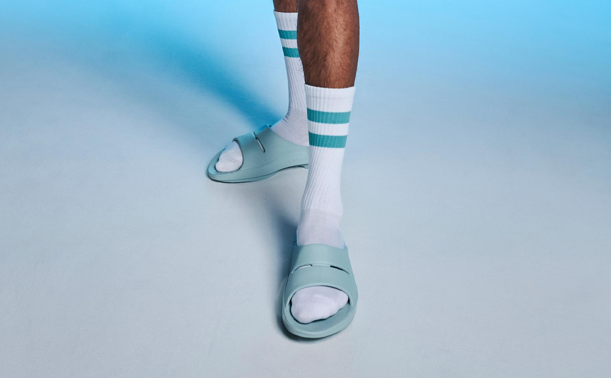 Men's OOahh Slide Sandal - Mist model standing in studio with blue background | lifestyle