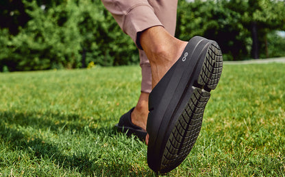 Women's OOmega OOahh Sandal - Black lifestyle close up image of shoe on model outside | lifestyle