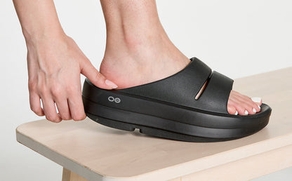 Women's OOmega OOahh Sandal - Black studio close up image of side of shoe on model | lifestyle