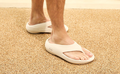Chalk sandals worn on feet standing on a carpeted floor | lifestyle