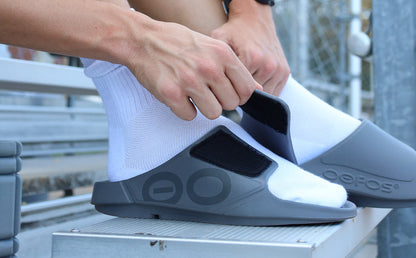 Men's OOahh Sport Flex Sandal - Slate lifstyle close up image of model adjusting strap on shoe | lifestyle