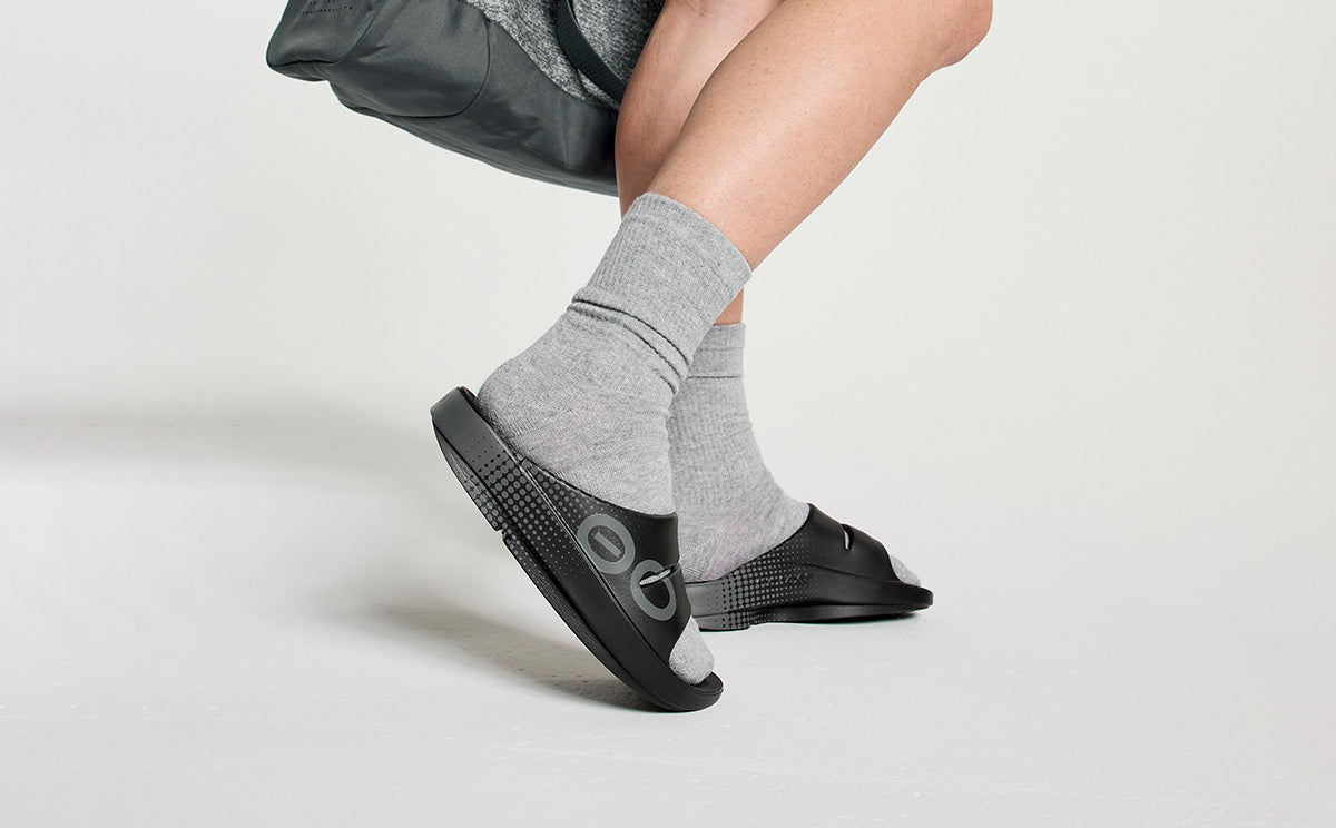 Women's OOahh Sport Slide Sandal - Black Matrix model in studio carrying gym bag | lifestyle