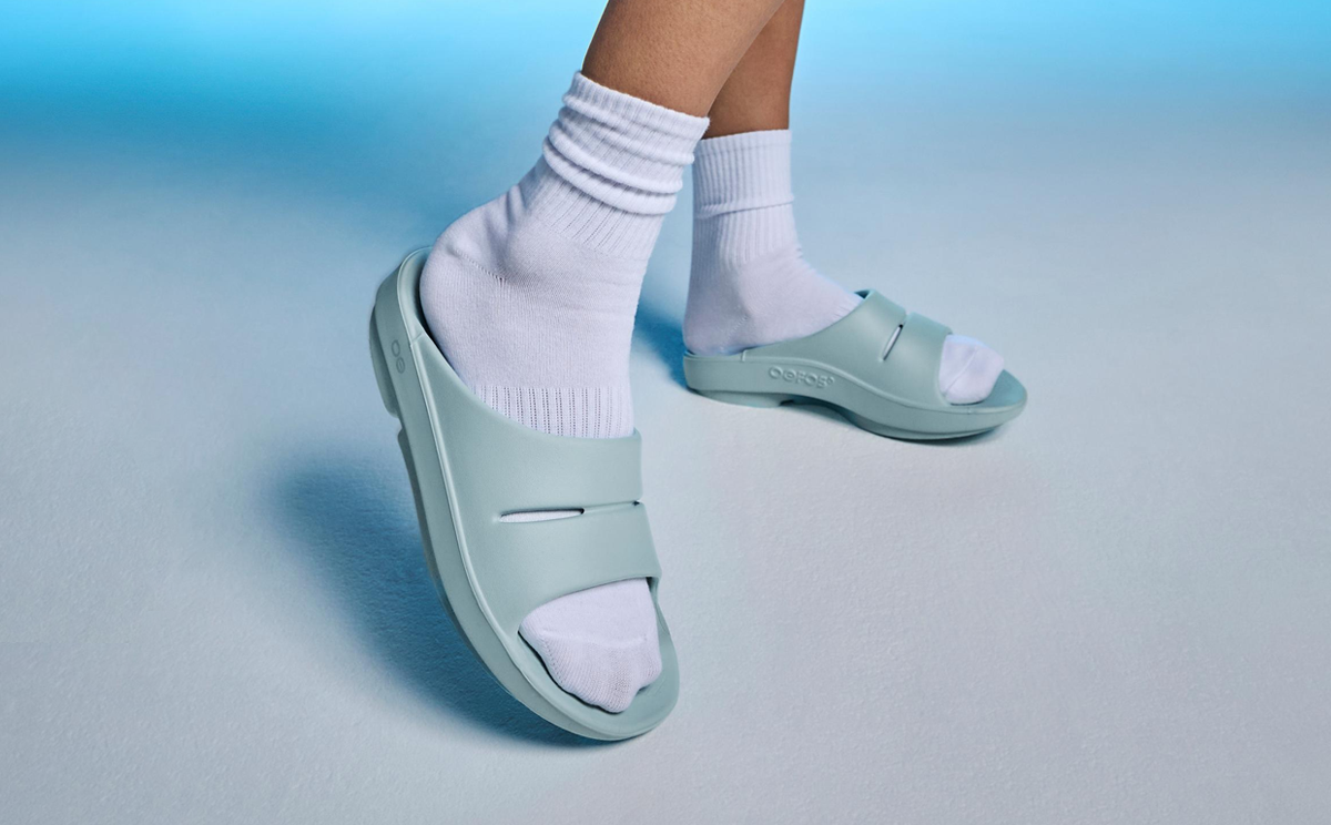 Women's OOahh Slide Sandal - Mist model standing in studio with blue background | lifestyle