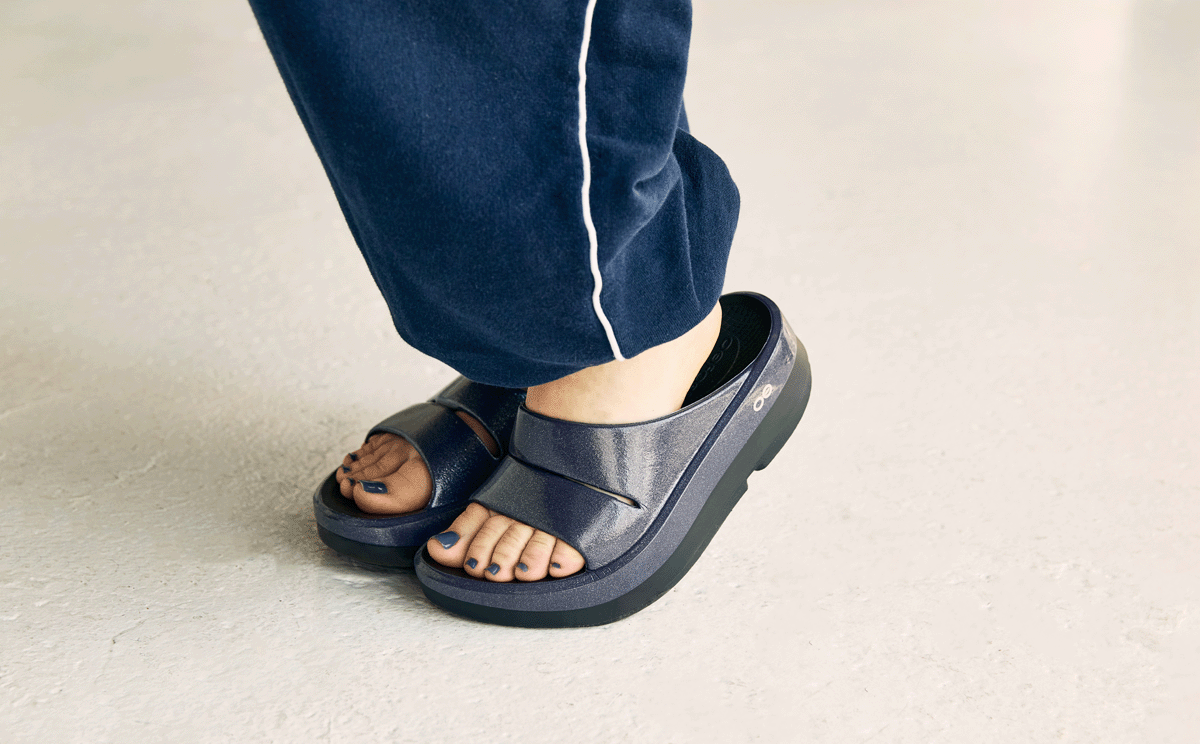 Person wearing purple sandals on a light background | lifestyle