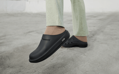 Women's OOcloog Clog - Black model lifting up leg standing outside | lifestyle