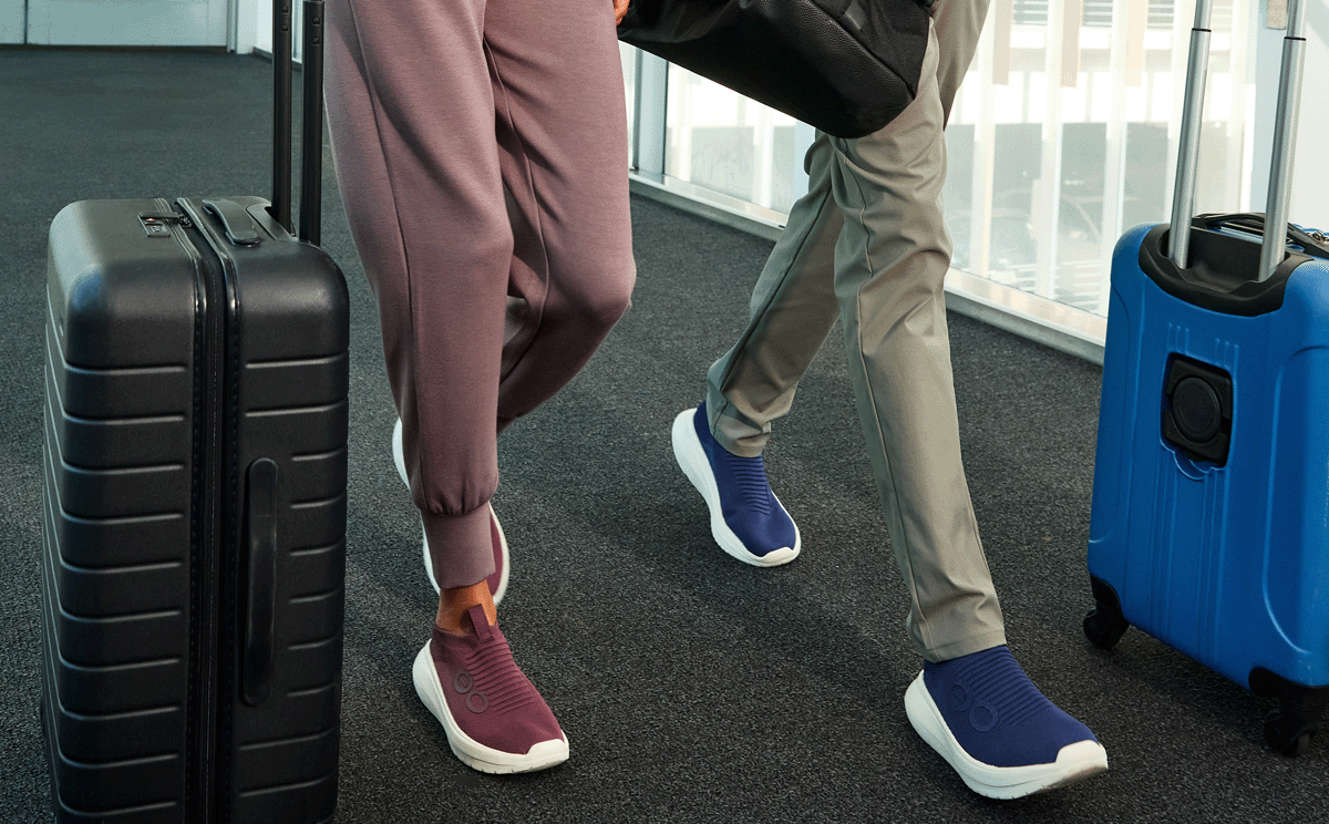 Two people with luggage in an airport setting