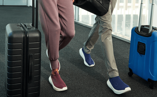 Two people with luggage in an airport setting