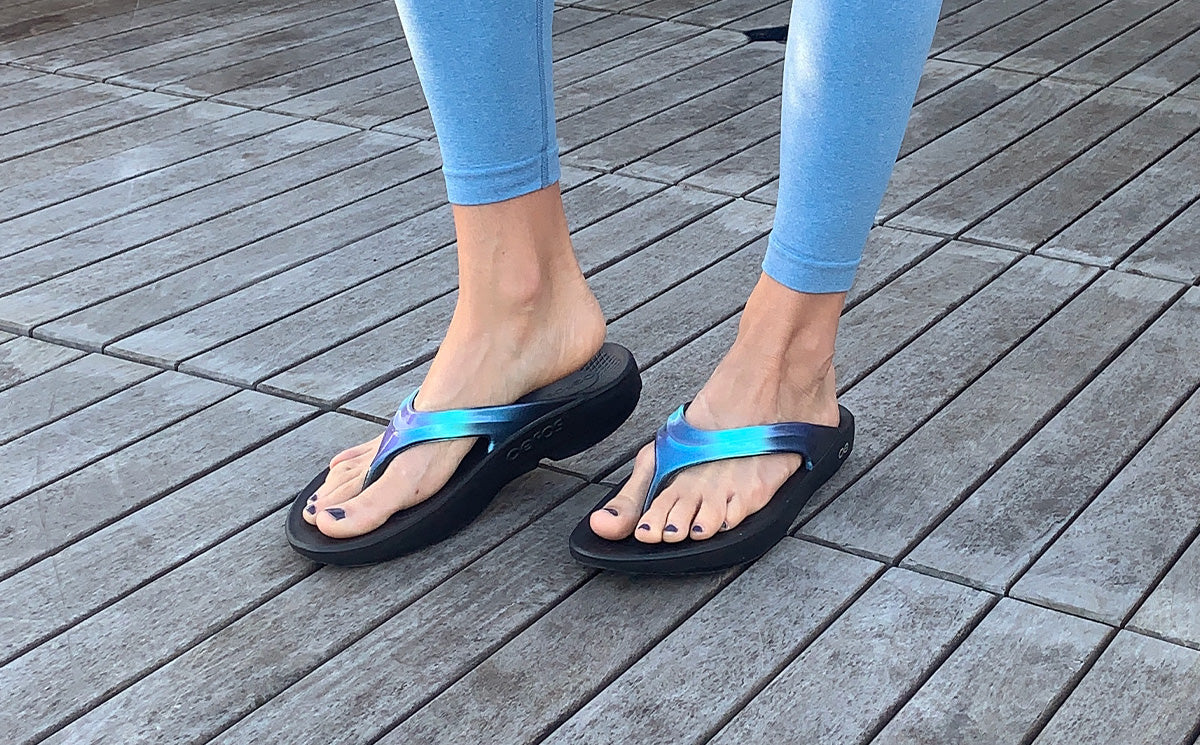Women's OOlala Luxe Sandal - Atlantis model wearing shoes standing on deck