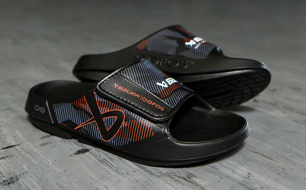 BAUER/OOFOS Men's OOahh Sport Flex Sandal – Black close up image of design on shoes